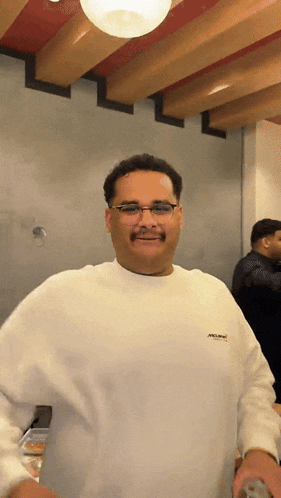 a man wearing glasses and a white sweatshirt with the word abercrombie on it
