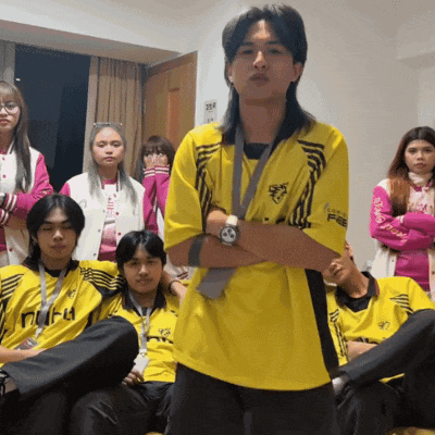 a man in a yellow shirt with a medal around his neck is standing in front of a group of young people