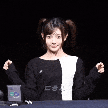 a girl in a black and white sweater is giving a peace sign