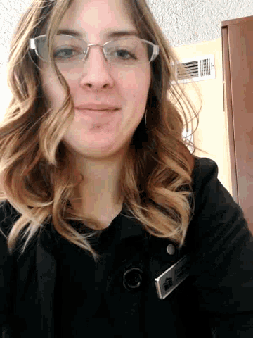 a woman wearing glasses and a name tag that says ' a. '