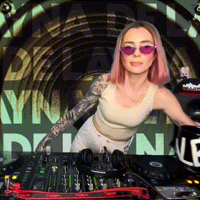 a woman wearing pink sunglasses is standing in front of a dj 's desk .