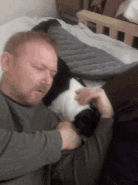 a man is laying on a bed with a cat
