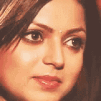 a close up of a woman 's face with a red lip and a bindi on her forehead .