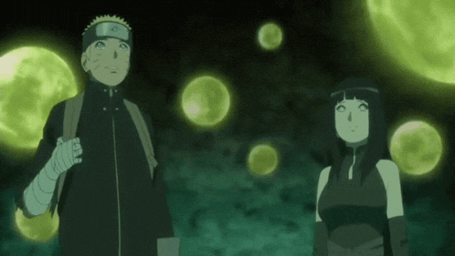 a man and a woman are standing next to each other in a dark room with glowing balls in the background .