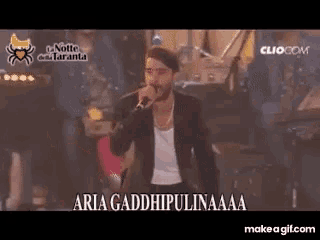 a man singing into a microphone with the words aria gaddhipulinaaa