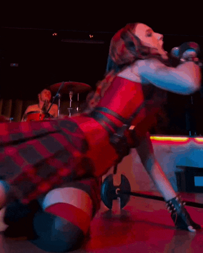 a woman is kneeling down in front of a drum that has the word genesis on it
