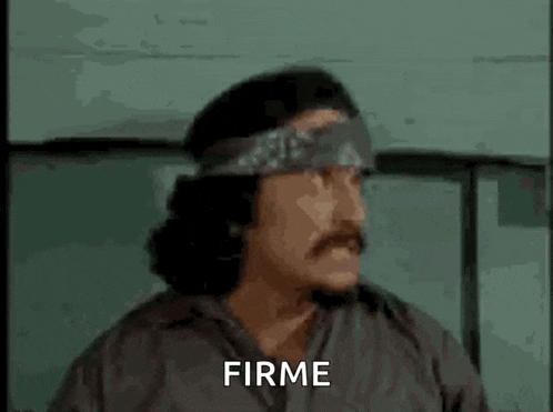 a man with a bandana on his head is making a funny face and says firme .