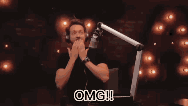 a man wearing headphones is covering his mouth with his hands and the word omg is written below him