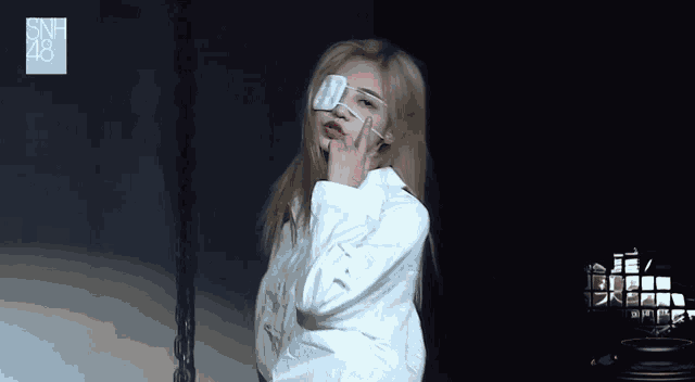 a woman wearing glasses and a white shirt with snh48 written on it