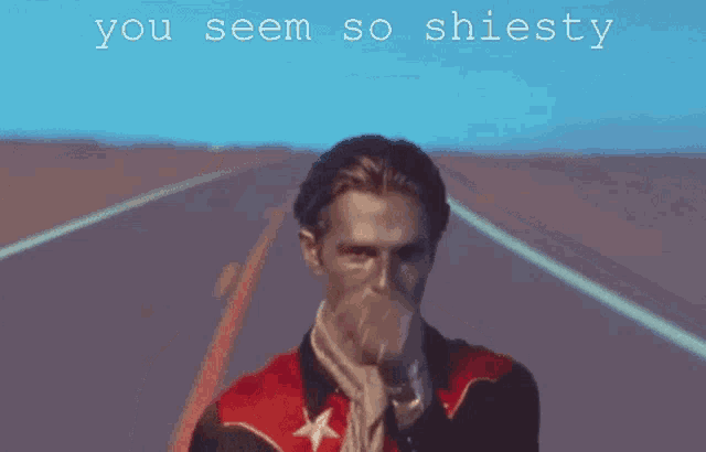 a man in a red jacket is pointing at the camera with the words " you seem so shiesty " below him