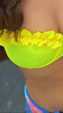 a woman in a neon yellow bikini top and blue bikini bottoms