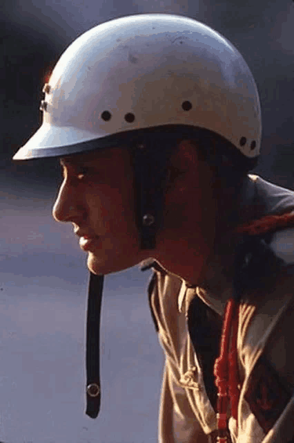 a man wearing a white helmet and a tan shirt