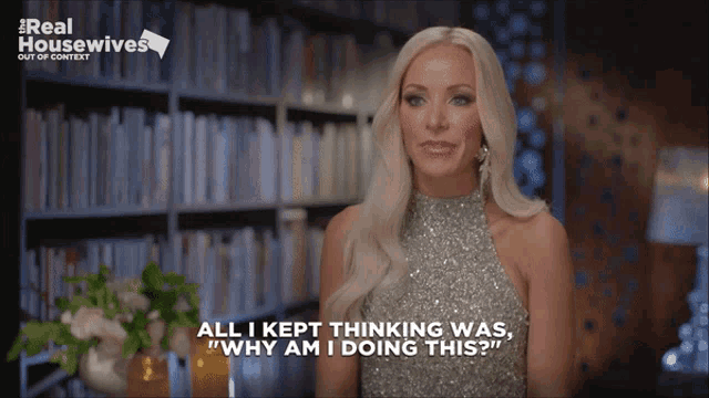 a woman says " all i kept thinking was why am i doing this " in front of a bookshelf