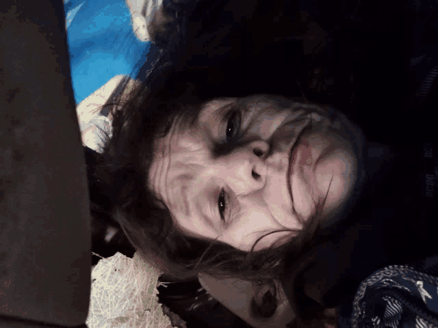 a close up of a person 's face with a blue blanket in the background that says ' abercrombie & fitch '