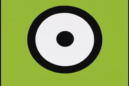 a close up of a green cartoon character 's eyes with a white circle in the center .