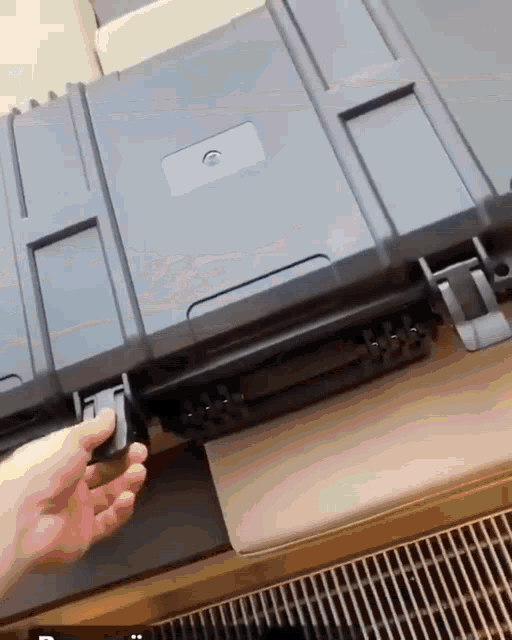 a person is opening a black plastic case with a lock on the side
