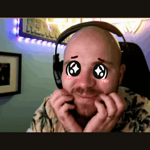 a bald man wearing headphones has a sticker on his face that says ' i love you '