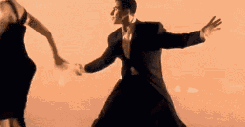 a man in a suit and a woman in a dress are dancing together .