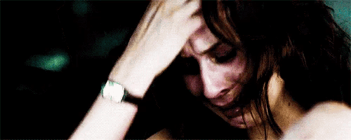 a woman with a watch on her wrist is crying with her hand on her head .