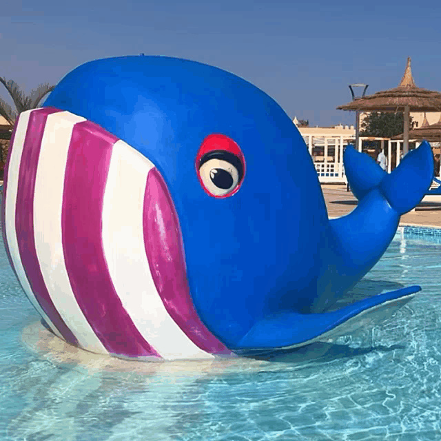 a blue and pink whale is in a pool