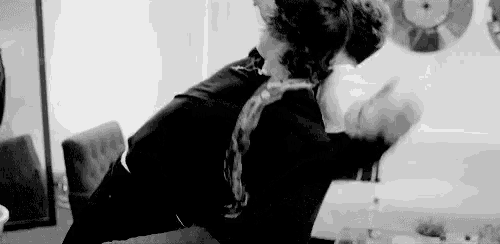 a black and white photo of a man holding a woman in his arms in a living room .