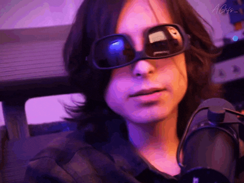 a close up of a person wearing sunglasses and headphones