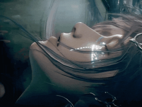 a close up of a woman 's face with water coming out of her mouth