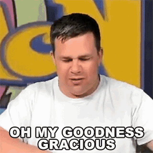 a man in a white t-shirt is making a funny face and saying `` oh my goodness gracious '' .