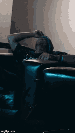 a man sitting on a couch with his hand on his forehead and the website imgflip.com visible