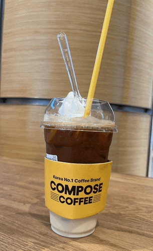 a cup of compose coffee with whipped cream and a straw
