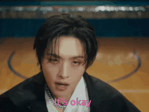 a close up of a man 's face with the words it 's okay in pink letters