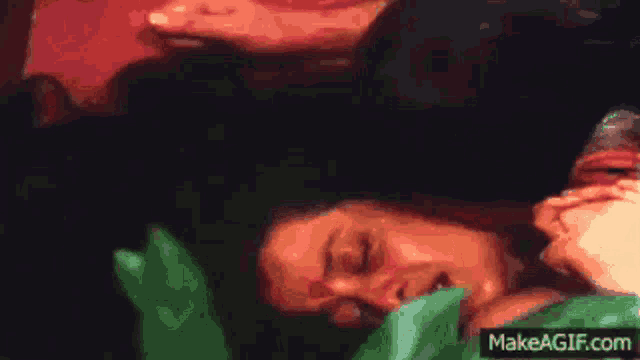 a man is kissing a woman 's forehead in a make a gif video .