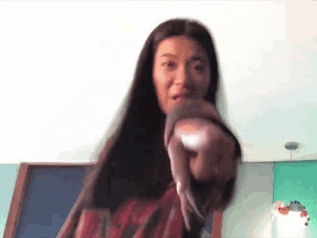 a woman with long hair is pointing at something