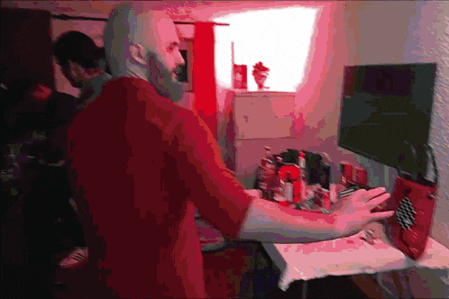 a man in a red shirt stands in front of a window