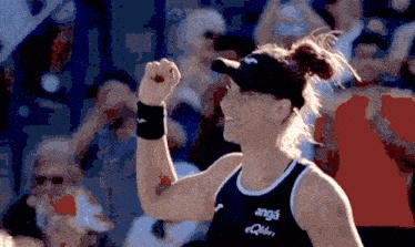 a woman wearing a black tank top with anga on it
