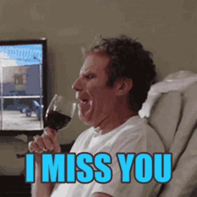 a man sitting in a chair with a glass of wine and the words i miss you behind him