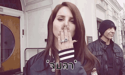 a woman with a ring on her finger is blowing a kiss