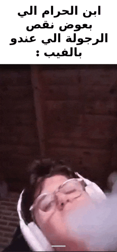 a man wearing glasses and headphones is blowing a bubble with arabic writing .