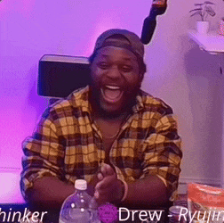 a man in a plaid shirt is sitting at a table with a bottle of water in front of him