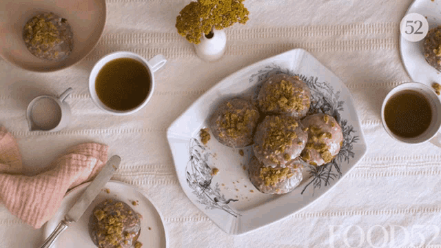 a plate of food sits on a table next to cups of tea