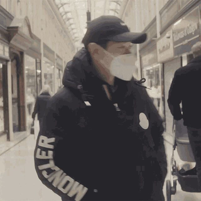 a man wearing a face mask and a jacket that says moncler