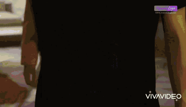 a person is holding a pink and green object behind their back and the words vivavideo are on the bottom of the screen