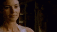 a close up of a woman 's face in a dark room in a blurry photo .
