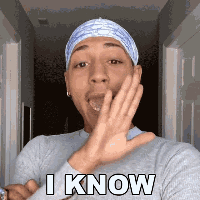a man wearing a headband says " i know " with his hand