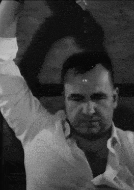 a man in a white shirt is standing with his arms in the air