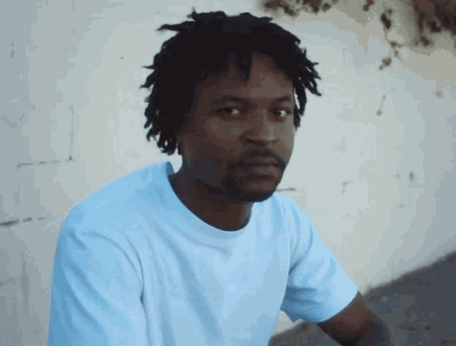 a man with dreadlocks wearing a white shirt