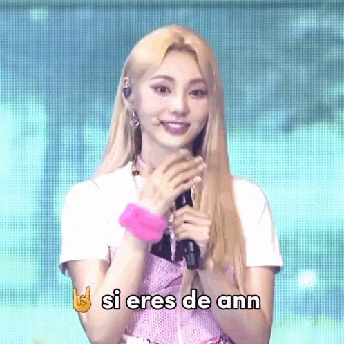 a woman singing into a microphone with the words si eres de ann written above her