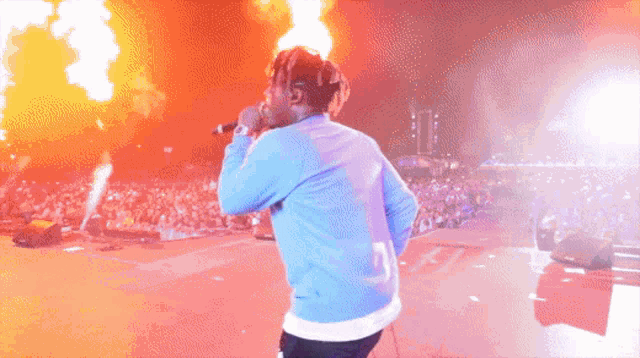 a man is singing into a microphone with flames coming out of it