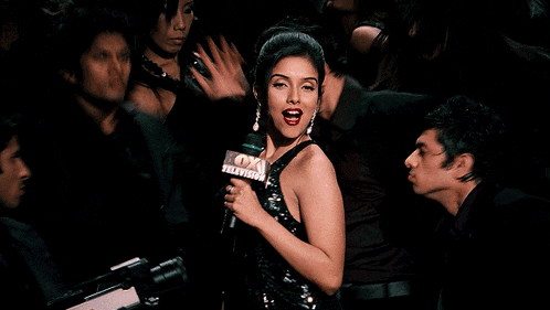 a woman singing into a microphone in front of a group of men