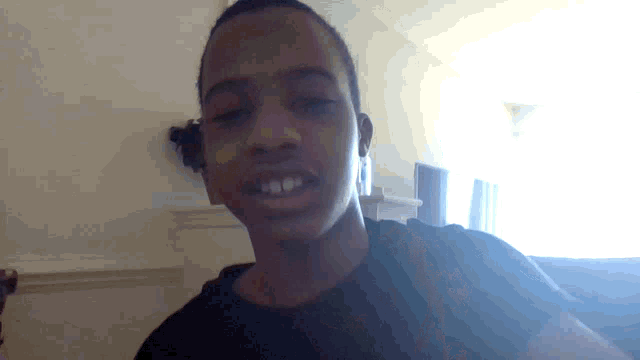 a young man in a black shirt is looking at the camera with his eyes closed
